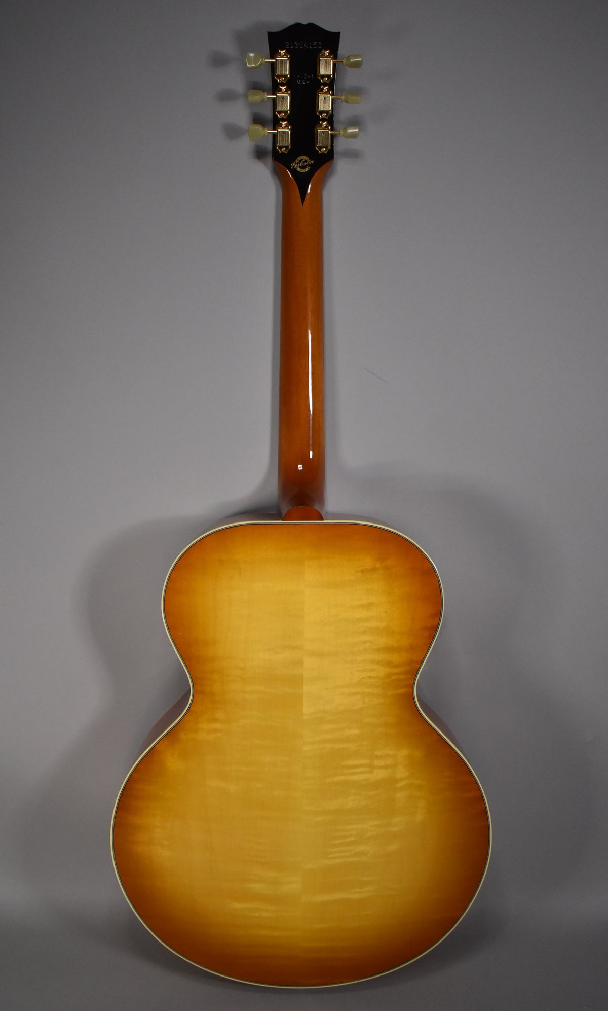 Full rear view of the acoustic guitar, showing the cherry sunburst finish with flame maple grain and cream binding.