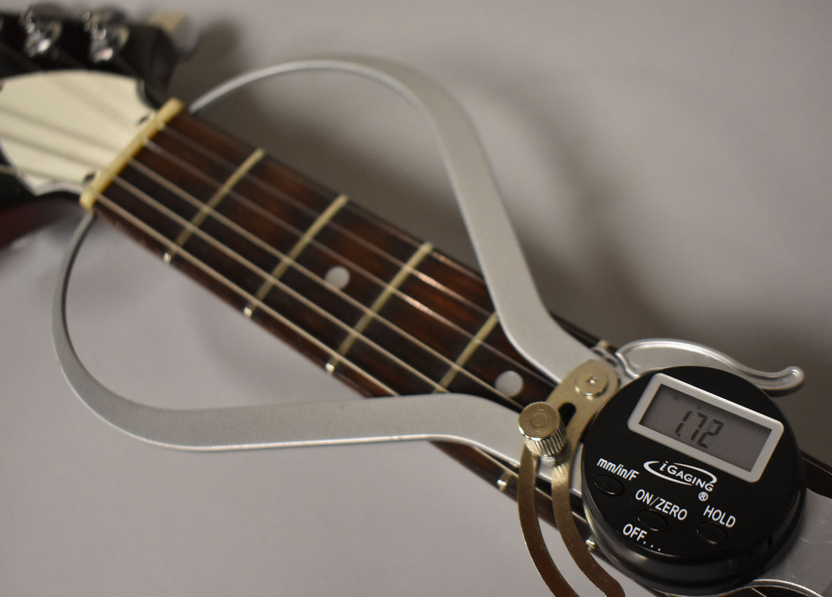 A digital caliper measures the dark rosewood fretboard at the nut, showing 1.72 inches, with a cream-colored nut and headstock visible.