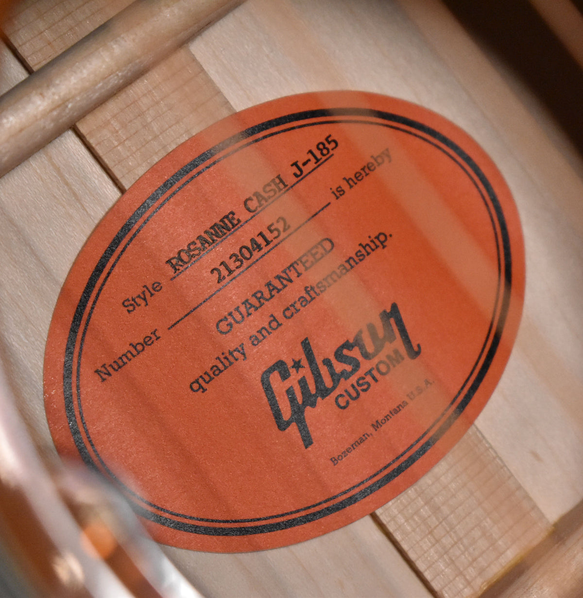 Close-up of the orange oval label inside the soundhole, showing the serial number and "Gibson Custom" logo.