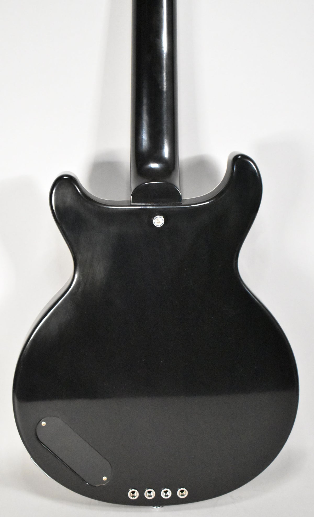 The bass's glossy ebony back shows light scuffs, a black control plate, and four chrome ferrules for the strings.