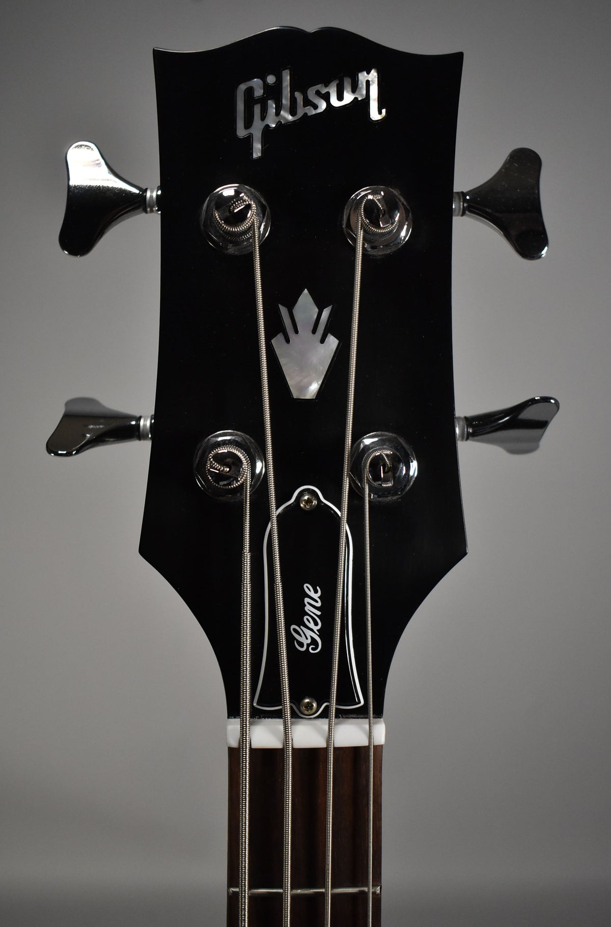 The black headstock, with a mother-of-pearl "batwing" inlay and "Gene" on the truss rod cover, features four chrome tuners.