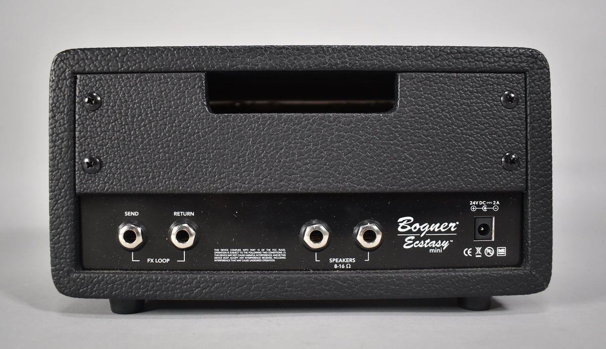 Rear view of the black textured amp head, showing the FX loop, speaker outputs, and power input.