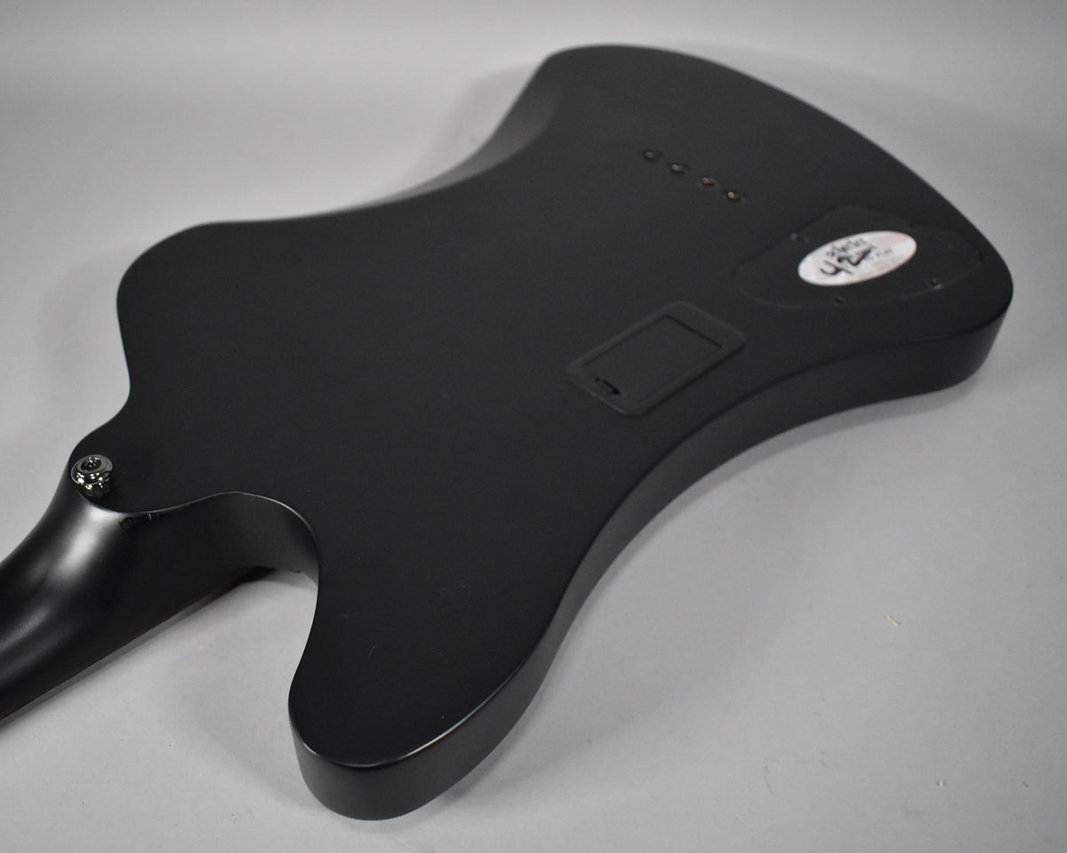 The bass's satin black back shows a battery compartment, control cavity cover, and four string ferrules.
