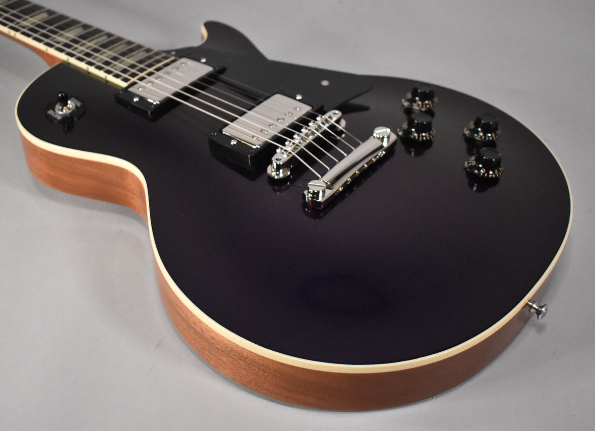 The upper body of a dark purple guitar with chrome hardware, black knobs, and natural wood sides, viewed from above.