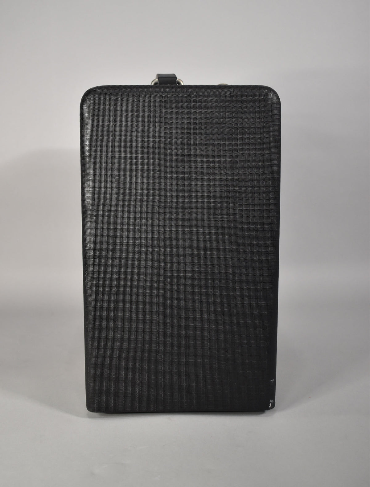 The black textured amp is viewed from the side, showing a top handle and minor scuffing on the bottom right corner.