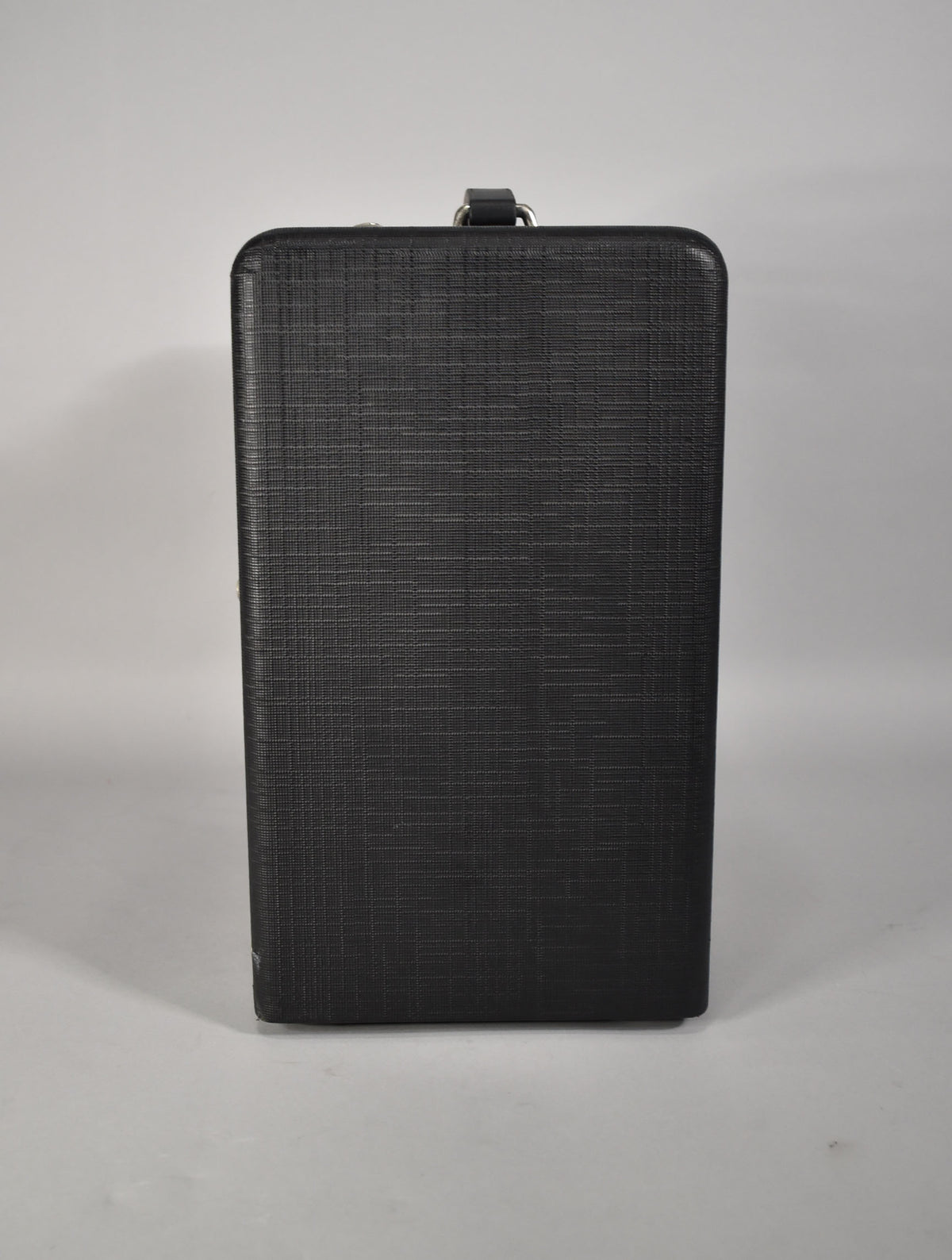The black amplifier, seen from the front, has a textured finish, a top handle, and a small scuff on the bottom left edge.