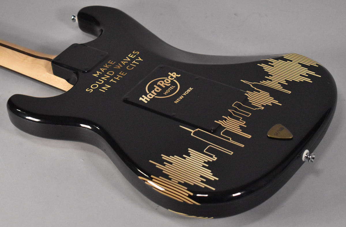 The black Stratocaster's back shows a gold Hard Rock Hotel NYC logo, "MAKE SOUND WAVES IN THE CITY" text, and a skyline graphic.