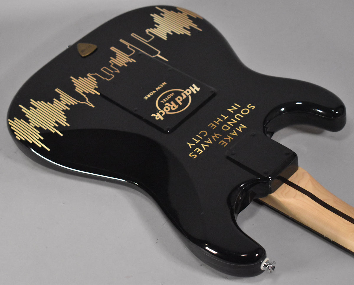 The black guitar body, viewed from the back, features gold Hard Rock Cafe NYC branding and "MAKE SOUND WAVES IN THE CITY" text.