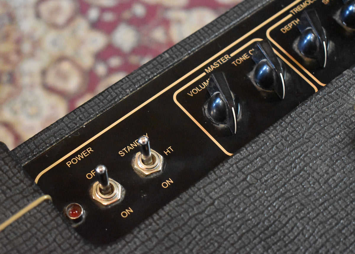 Close-up of a black Vox AC15C1 amplifier's control panel, showing power, standby, volume, tone cut, and tremolo depth knobs.