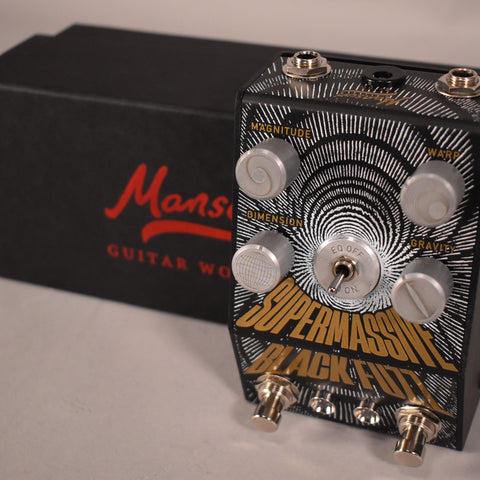 Black fuzz pedal with a white spiral graphic, five silver control knobs, a toggle switch, and three footswitches.