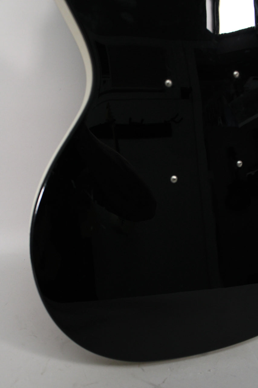 The lower bout of a glossy black electric guitar, with white binding along the curved edge and three chrome control knobs visible.