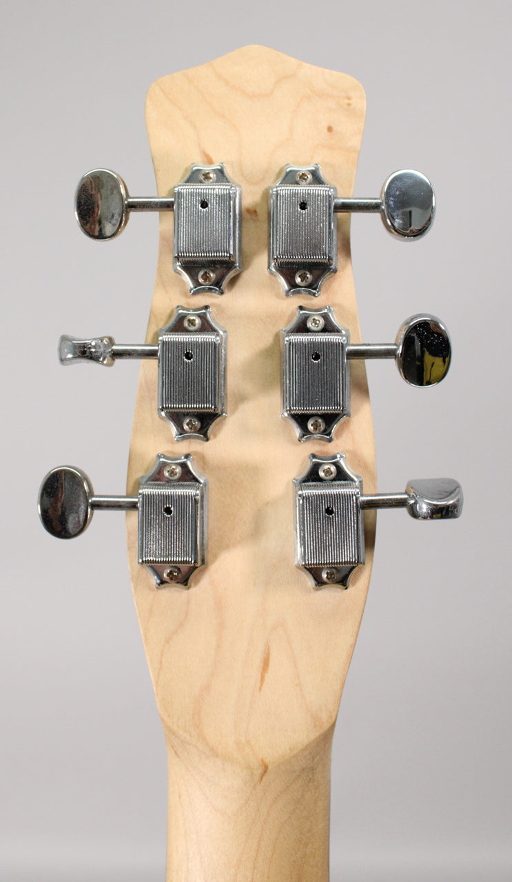 The back of a light wood guitar headstock with six chrome tuning machines, three on each side.