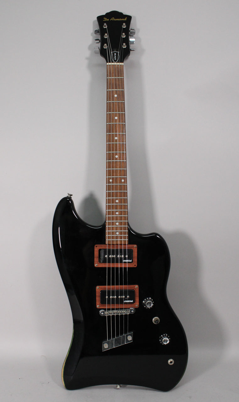 Full-length view of a glossy black electric guitar with a dark fretboard, two P90 pickups with wood surrounds, and four chrome knobs.