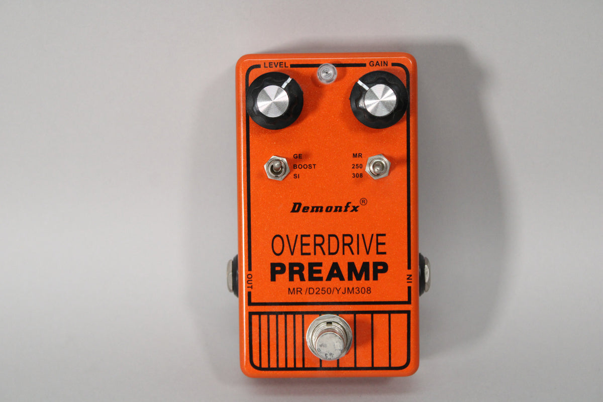 An orange guitar pedal with two black knobs, two small toggle switches, and a silver footswitch, viewed from above.