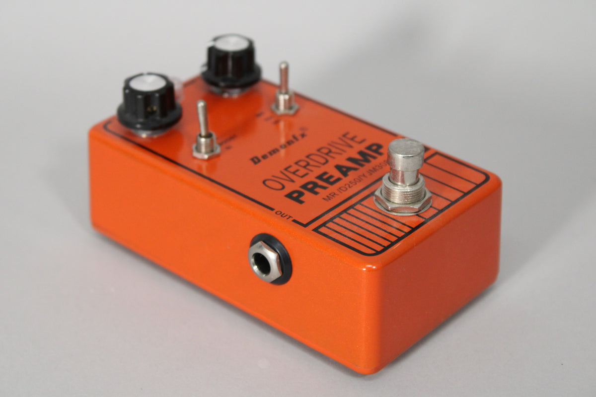 Orange pedal, angled from the left, showing two black knobs, two silver toggles, a footswitch, and an "OUT" jack.