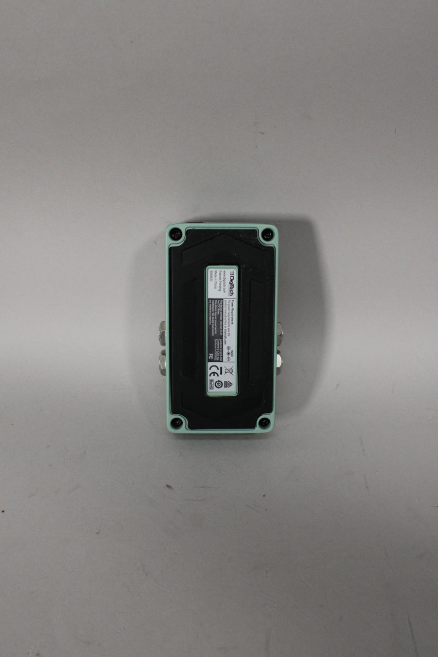 The reverb pedal is shown from the bottom, revealing a black base plate with a white label and four visible screws.