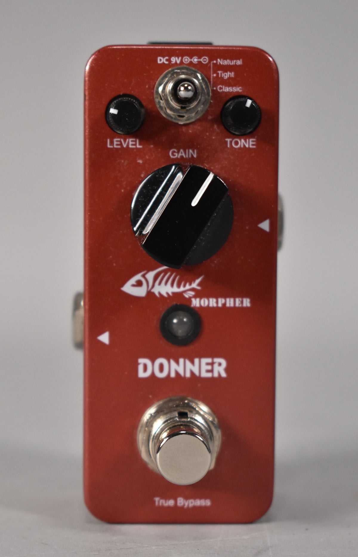 A red distortion pedal, viewed from above, shows three black knobs for Level, Gain, and Tone, plus a footswitch.
