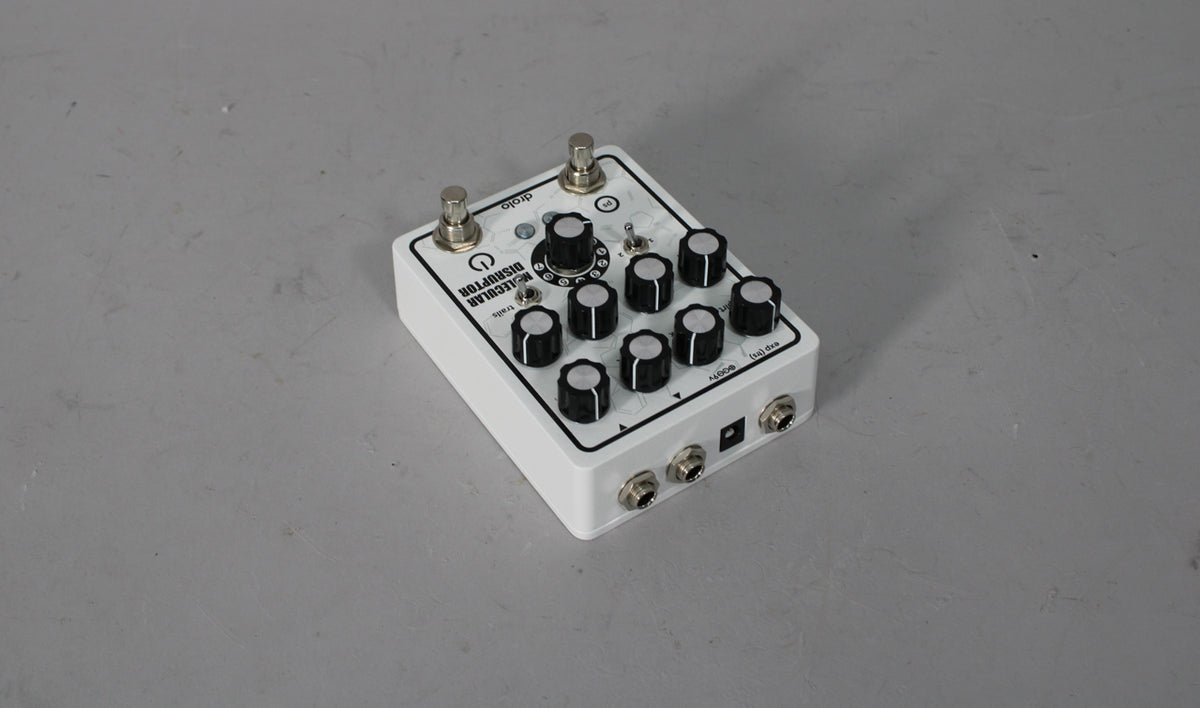 A white guitar pedal with black text and graphics, two footswitches, one large and eight small black knobs, and one toggle switch.