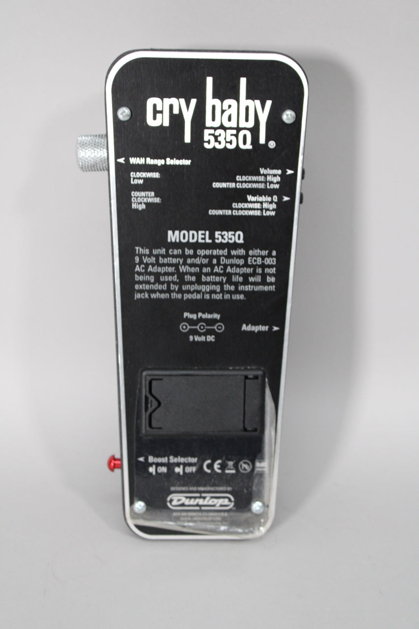 Close-up of the black Dunlop Crybaby 535Q Wah Pedal's underside, showing text, controls, and a battery compartment.