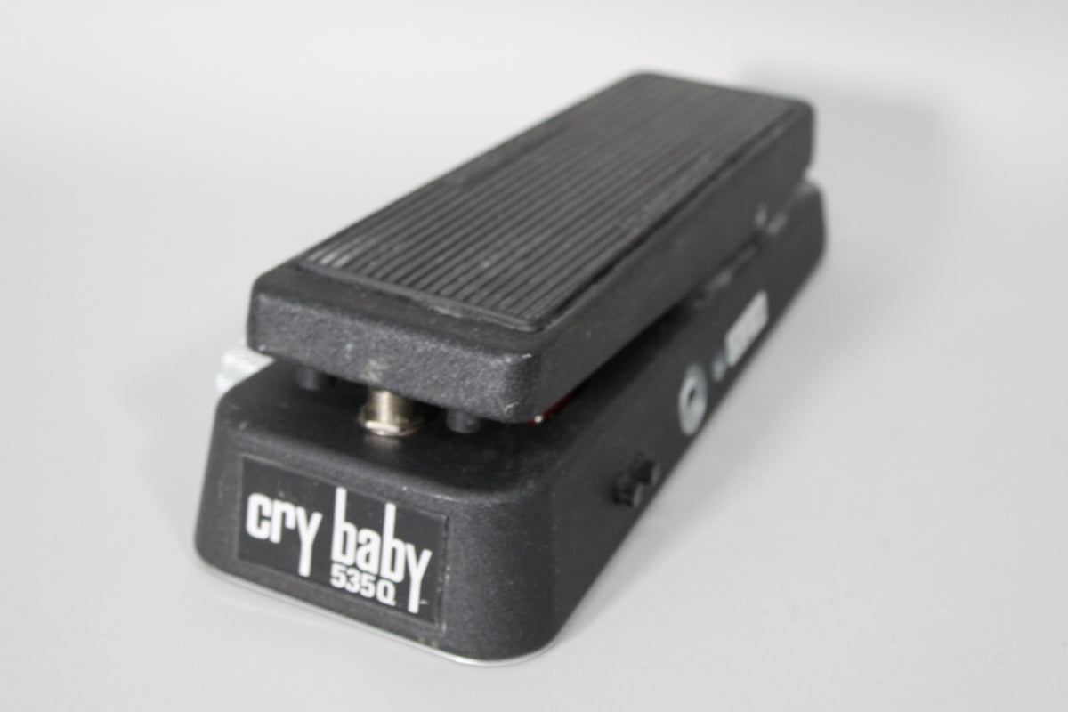 Black wah pedal, angled from the front right, showing the textured footpad, side controls, and some wear on the edges.