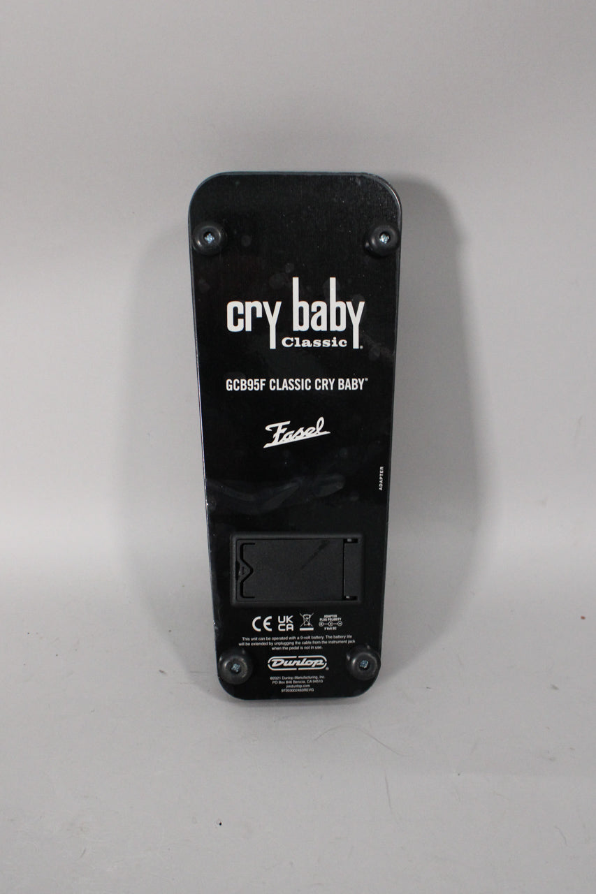 The black wah pedal is seen from the back, showing its base plate with four visible screws and a battery compartment.