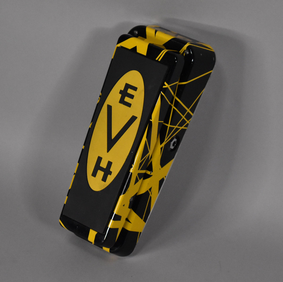 Black wah pedal with yellow stripes and an "EVH" logo, viewed from the front-right at an angle.