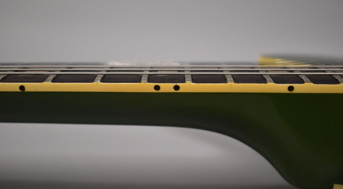 Close-up of the olive drab neck and yellowed binding, showing dark side dots and fret wear on the dark fretboard.