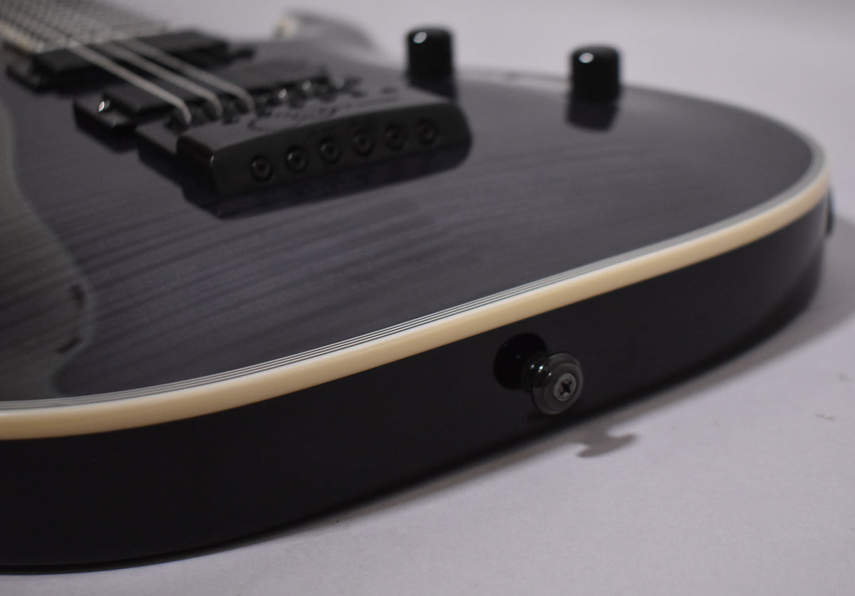 Close-up of the guitar's lower body, showing the charcoal burst finish, cream binding, black EverTune bridge, and two black control knobs.