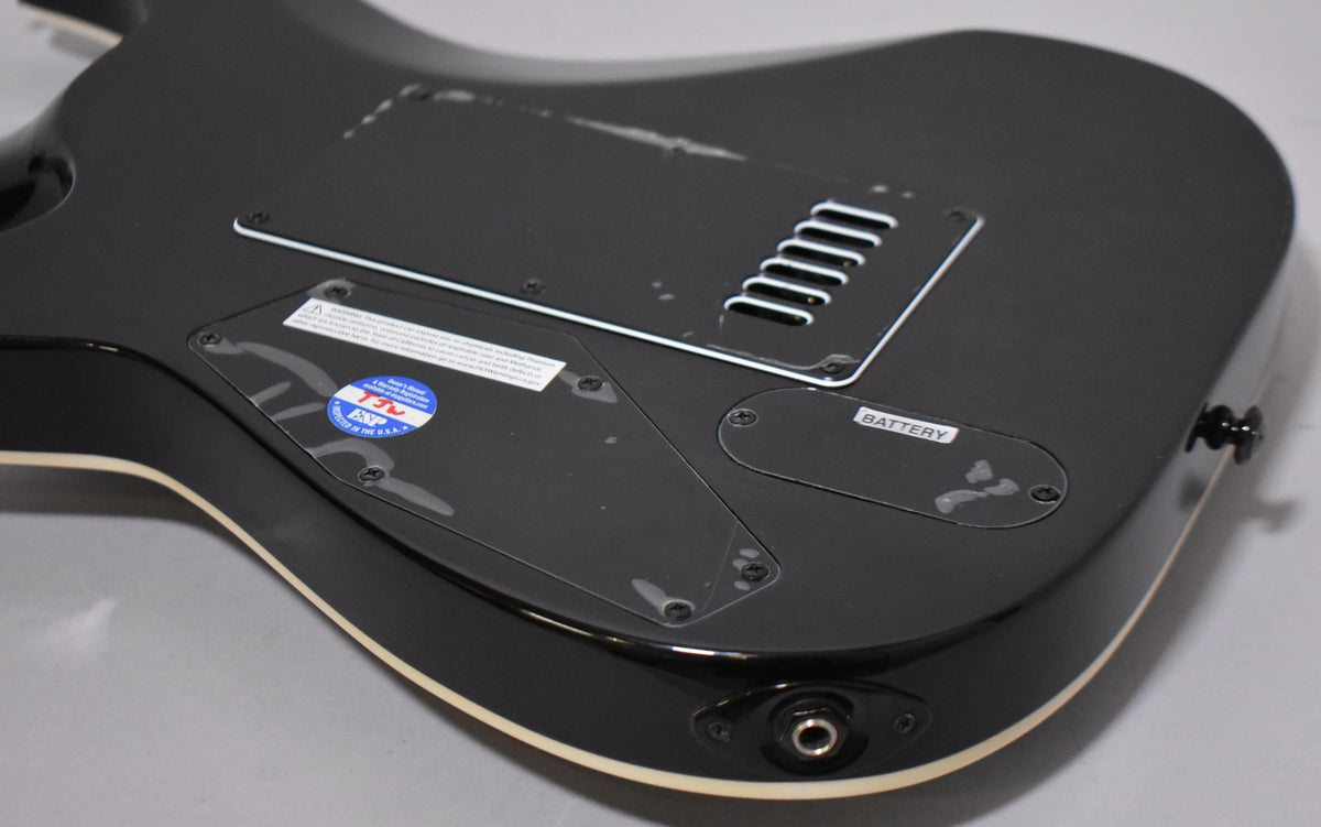 The charcoal burst guitar's back shows a matte finish with gloss edges, control cavity covers, and a "BATTERY" label.