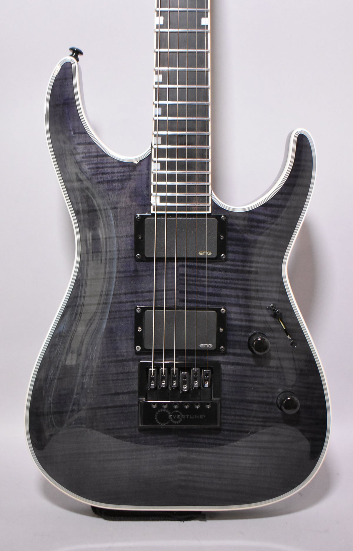 Full-frame view of a charcoal burst electric guitar with a flamed maple top, two black humbuckers, and an EverTune bridge.