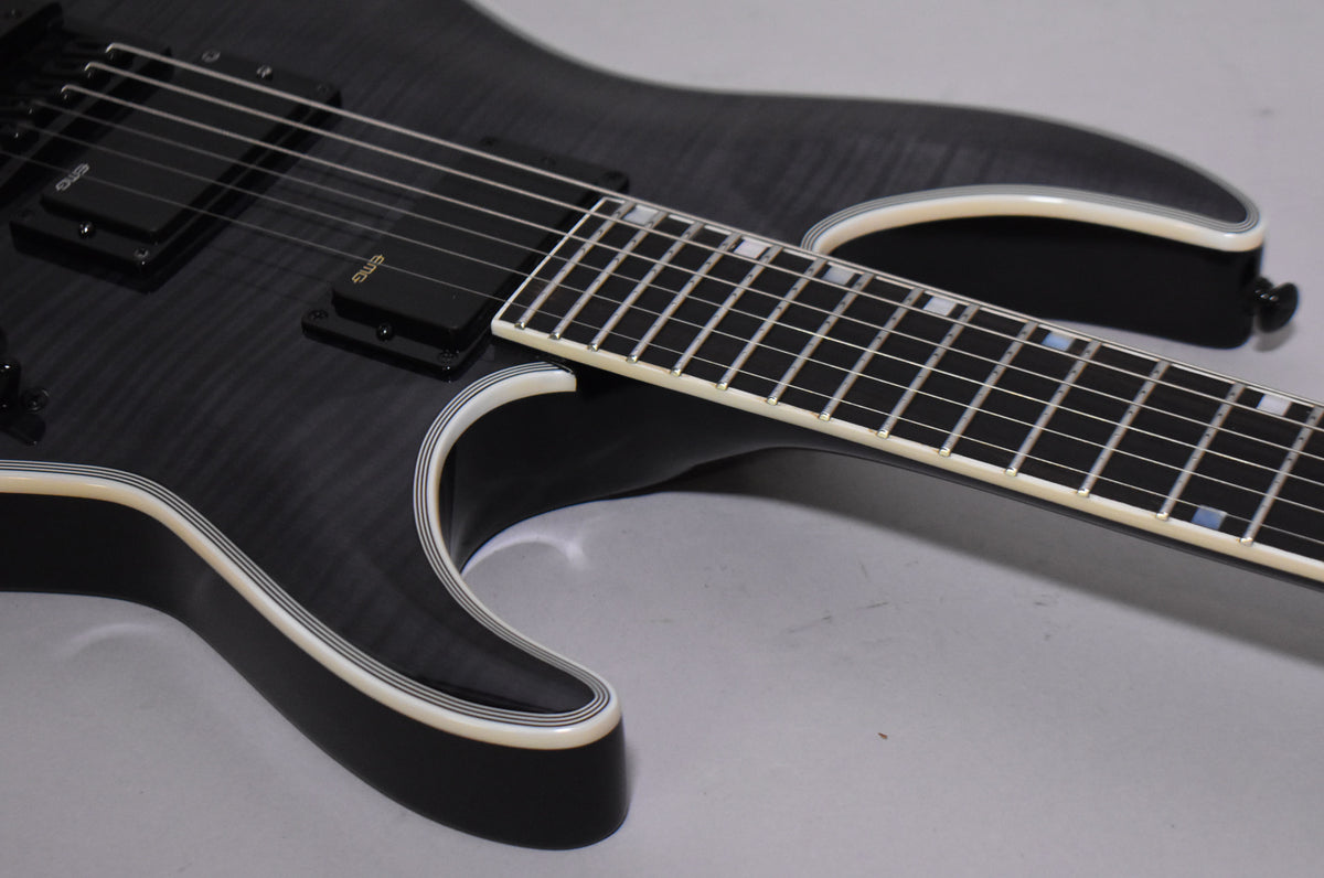 The guitar's upper body and fretboard are visible, showing a charcoal burst finish with white binding and black EMG pickups.