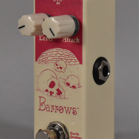 A cream-colored pedal with a red label featuring skulls, two cream knobs, a footswitch, and a side input jack.