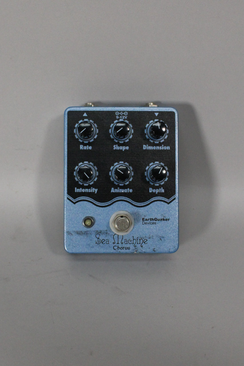 A light blue metallic pedal with a black control panel, six black knobs, a footswitch, and an indicator light.