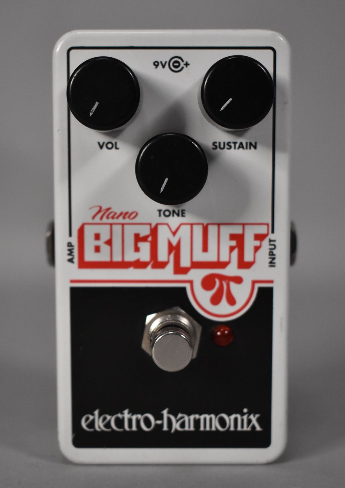 A white guitar pedal with a black bottom panel, three black control knobs, a silver footswitch, and a red indicator light.