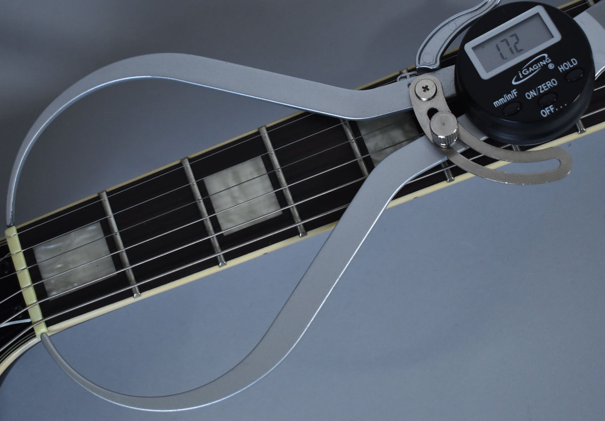 A digital caliper measures the fret height at 1.72mm on the ebony fretboard with rectangular mother-of-pearl inlays.