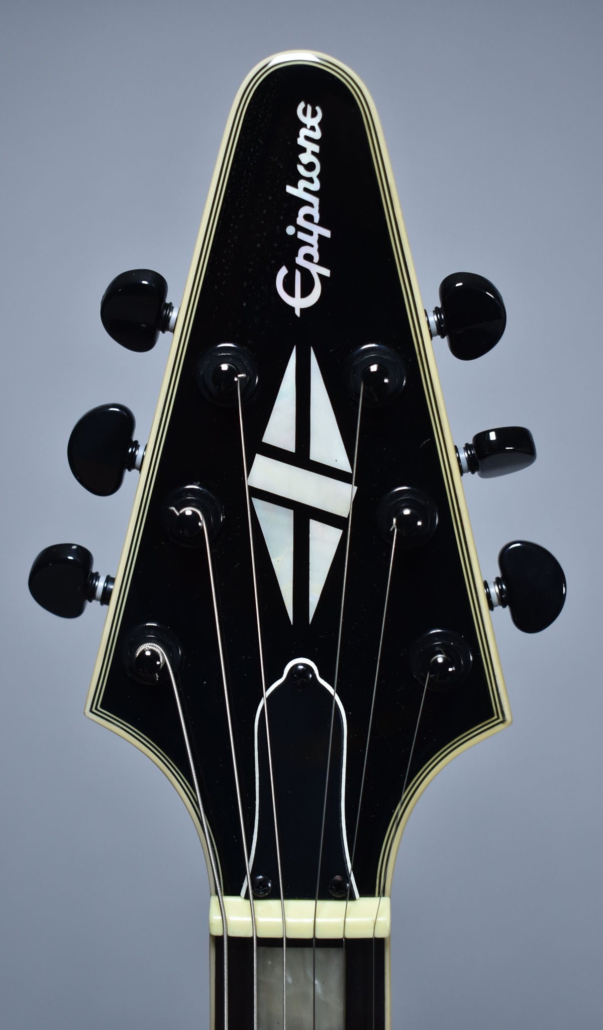 The black gloss headstock with cream binding features a mother-of-pearl inlay and six black tuning pegs.