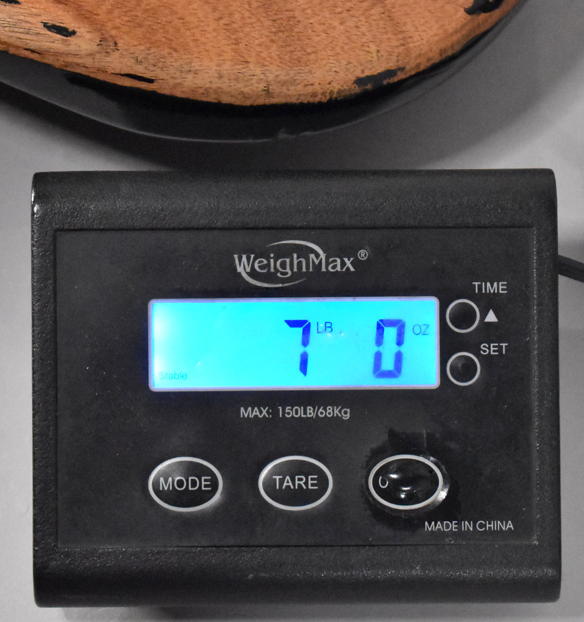 The guitar's sunburst body is shown from above, resting on a digital scale displaying "7 LB 0 OZ".