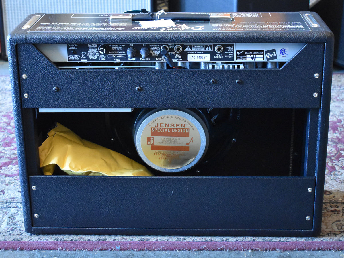 Rear view of the black textured amp, showing the Jensen Special Design speaker and a yellow bag inside.