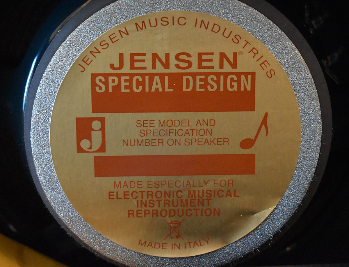 Close-up of the speaker's gold and orange label, showing a slight crease on the right side.