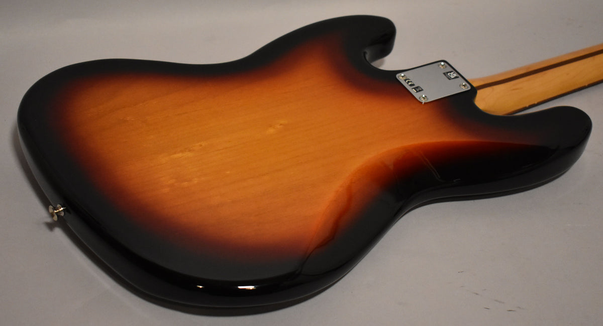 The back of the sunburst bass body, showing the neck plate, strap button, and a few light scratches on the lower bout.