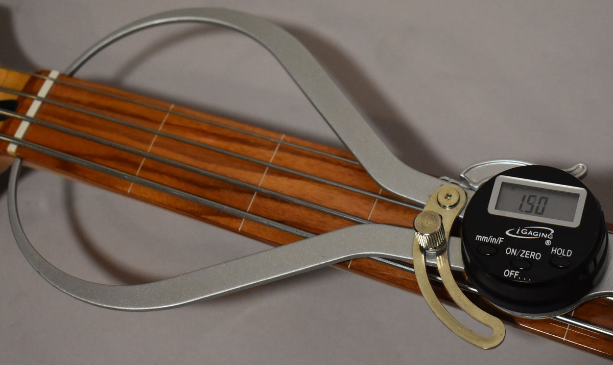 A digital caliper measures the fretless rosewood fingerboard, showing a 1.90mm reading.