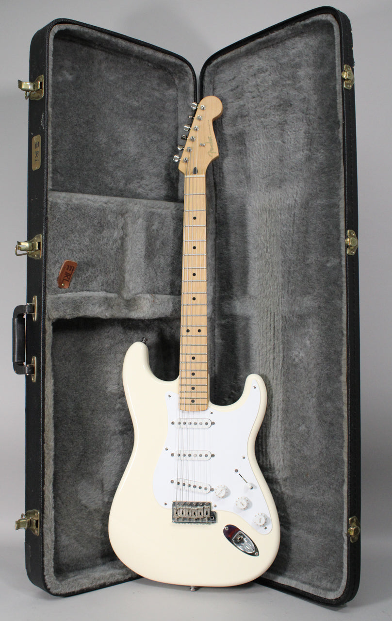 Full-length view of an Olympic White Stratocaster with a maple neck, white pickguard, and three single-coil pickups, resting in a black hard case.