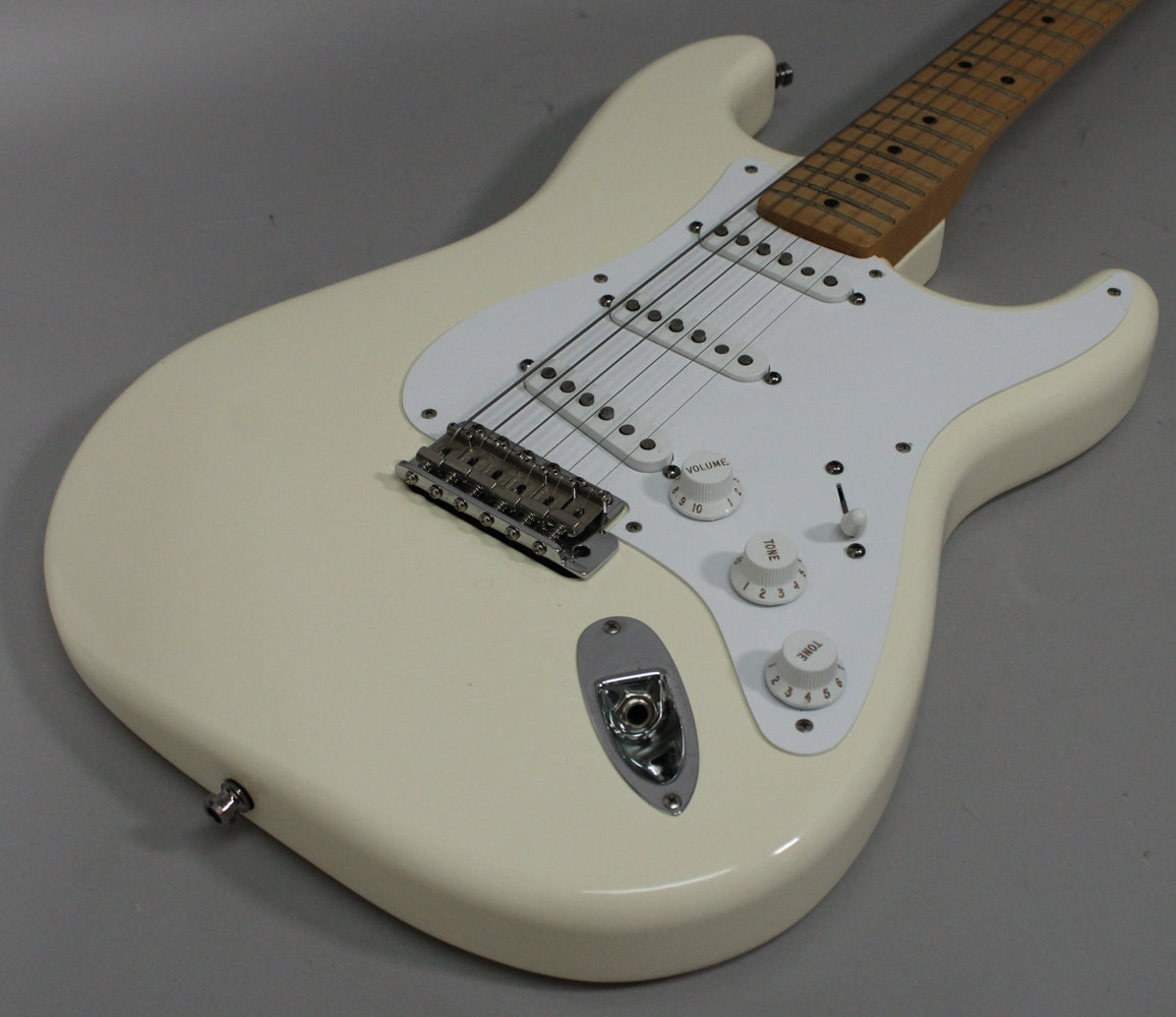 Olympic White Stratocaster body, angled from the lower bout, showing the white pickguard, three single-coil pickups, and chrome hardware.