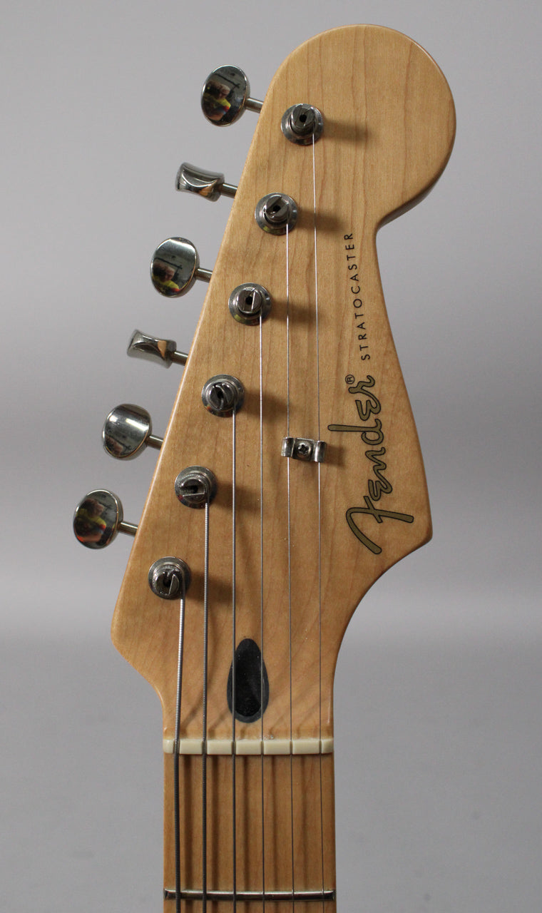 Close-up of the natural wood headstock and top of the maple neck, showing six chrome tuners and a black string tree.