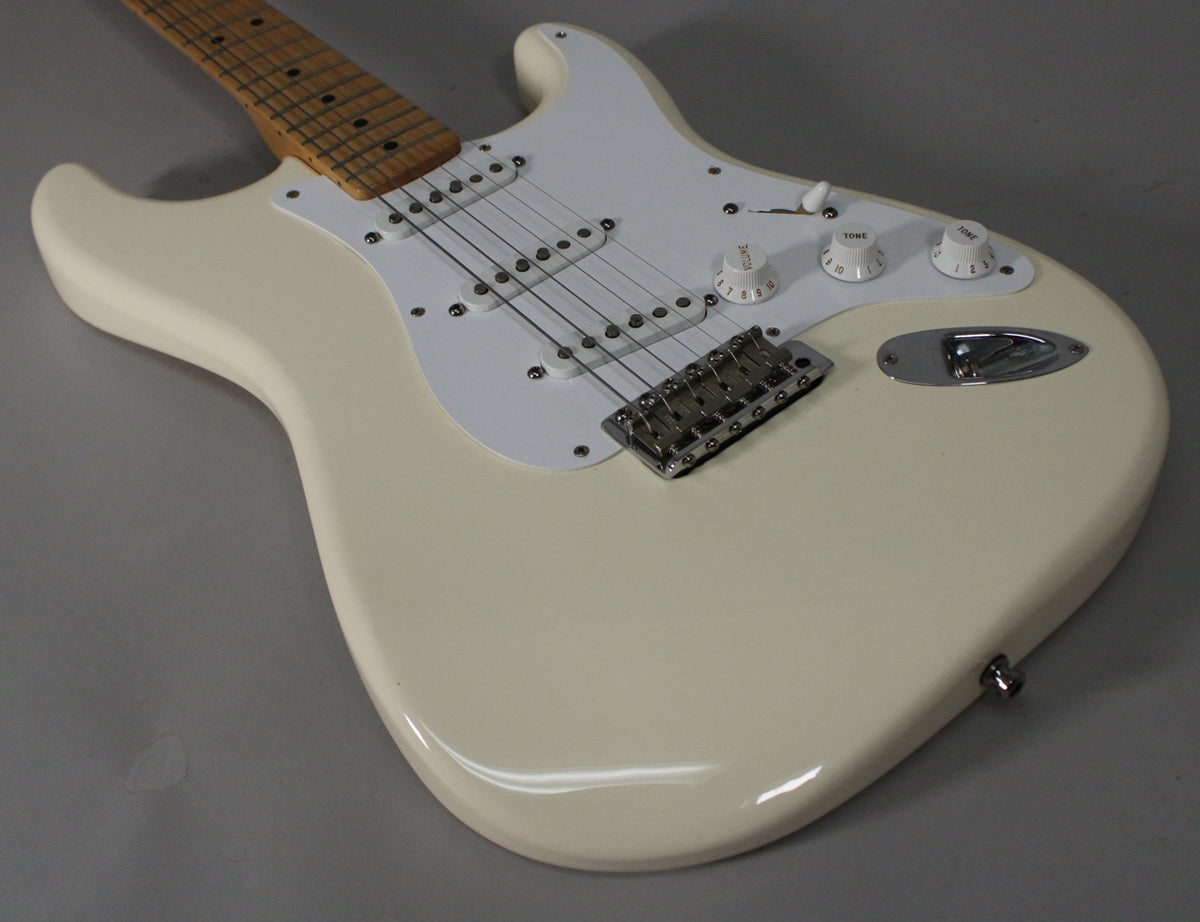 Upper body of an Olympic White Stratocaster, showing the maple neck, white pickguard, three white knobs, and chrome bridge.