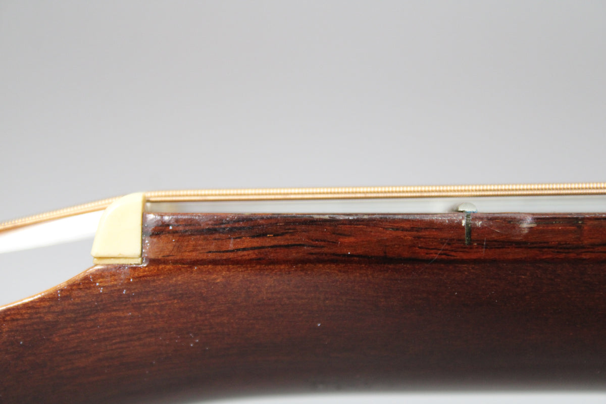 Close-up of the guitar's dark brown neck and fretboard, showing a cream-colored nut and a visible crack near the first fret.