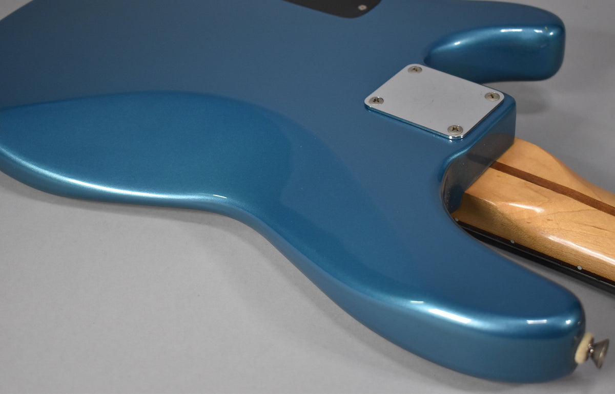 The bass's Lake Placid Blue body, with a metallic sheen, shows a chrome neck plate and a light maple neck.