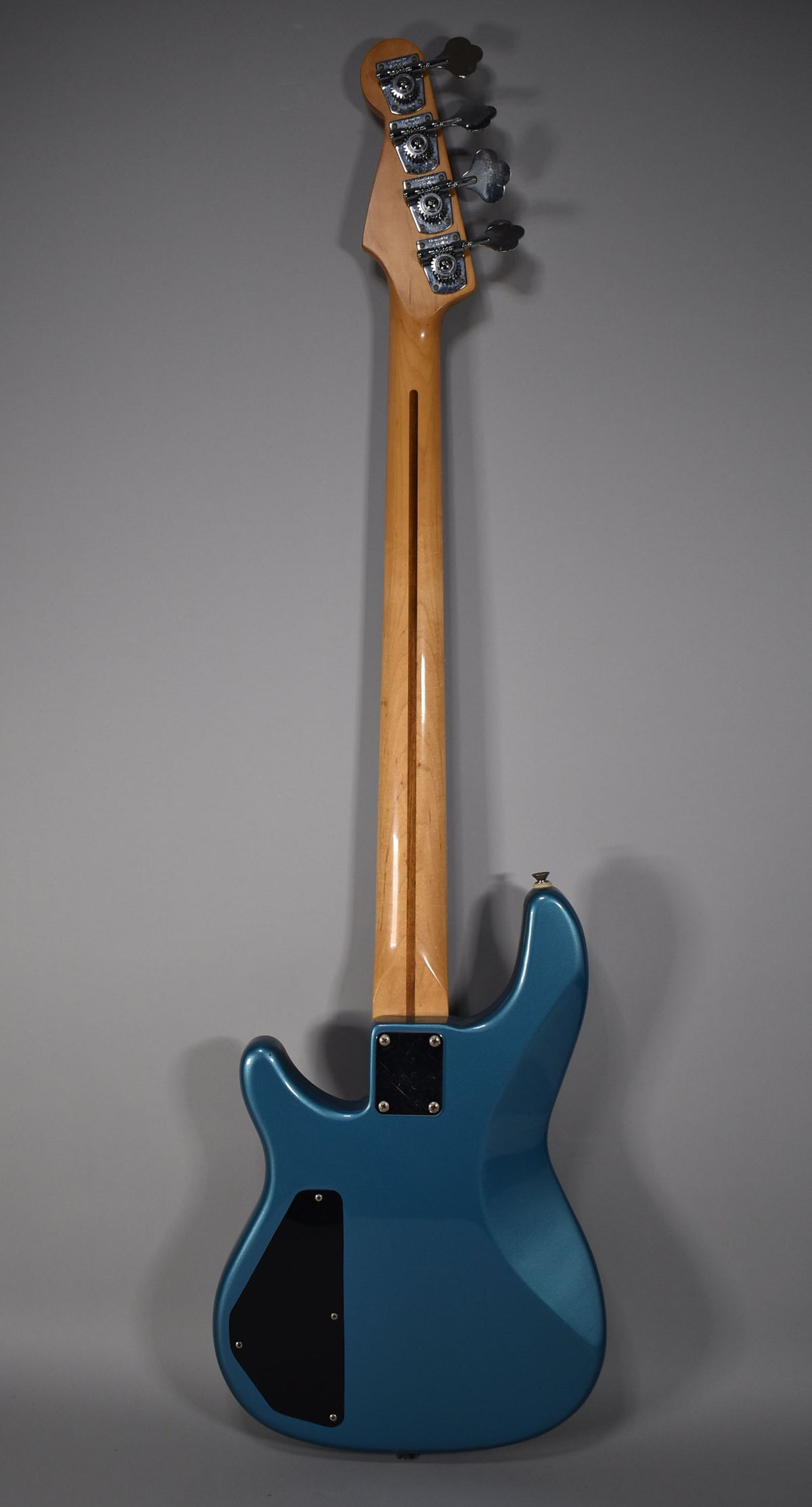 The bass is shown from the back, with a glossy Lake Placid Blue body, a light wood neck, and chrome tuners.
