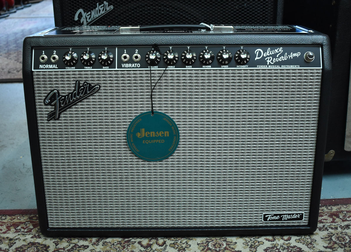 Front view of a black combo amp with a silver grille, black control panel, and a "Jensen Equipped" tag hanging from a knob.