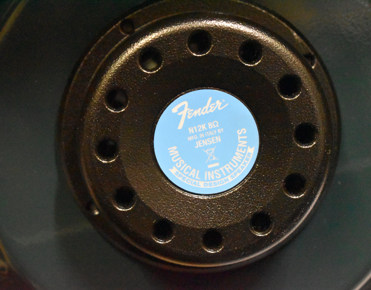 A close-up of the speaker's black, textured magnet, with a light blue label at its center.